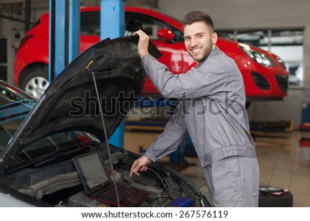 Mechanic testing an engine with a computer.