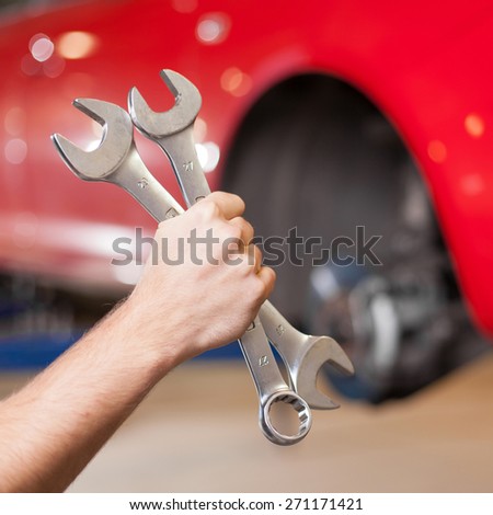 Hand Holding Two Wrenches