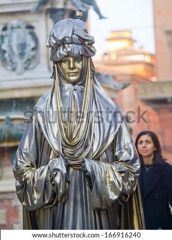 A human like removable sculpture is installed in Bologna\'s Piazza Maggiore. Street performers and art installations are tourist attractions in Bologna.