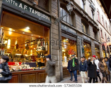 BOLOGNA, ITALY - JANUARY 25, 2014 - People walk along the famous traditional Italian shops in Bologna\'s center. The shops sell cheeses, meat, salami and other quality products.