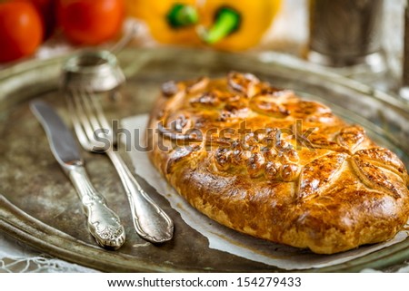 Traditional russian pie - kulebyaka on an old silver plate