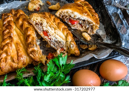 Traditional russian pie - kulebyaka. With parsley, dill and eggs. Some cut pieces of pie on a spoon. Close up