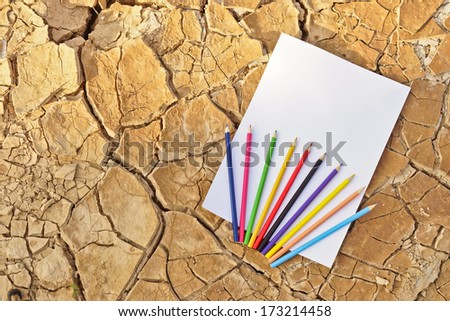 paper with color pencil on cracked earth / white paper on cracked earth / paper texture