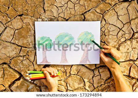 Hand drawing a picture of trees on cracked earth / growing tree / save the world / environmental problems / cut tree