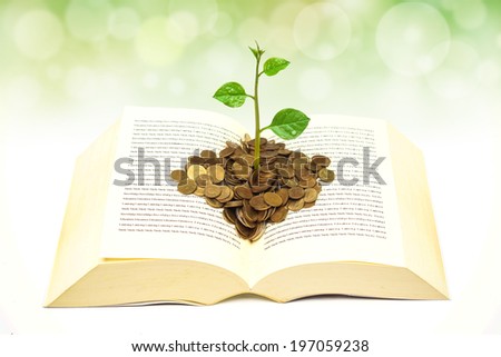 tree growing on coins over a big open book