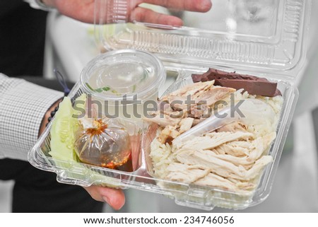 hands holding a plastic food box