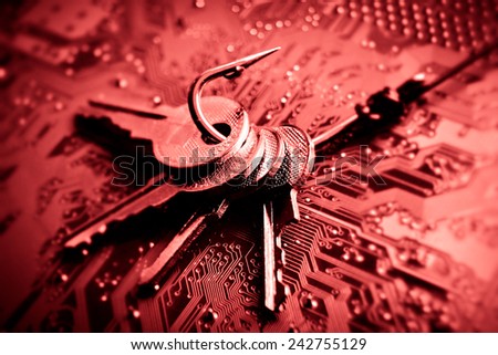 a fish hook with keys on computer circuit board / phishing / computer data theft concept