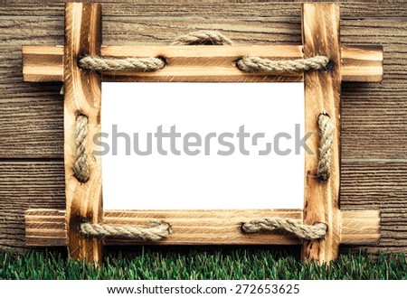 old wooden picture frame with white space on green grass floor with wood background