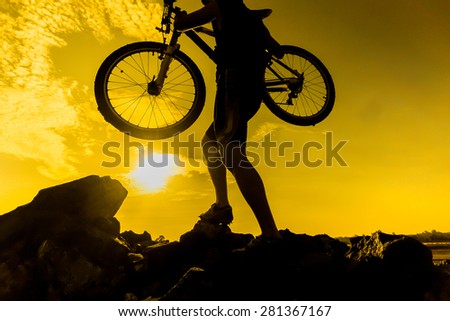 a cyclist with his mountain bike with sunset silhouette