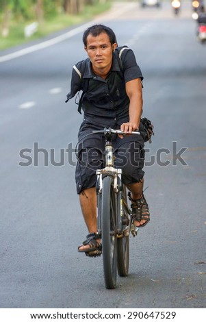Ubonratchathani, Thailand- May 21, 2013 : A man with one hand was riding a bicycle along the road.