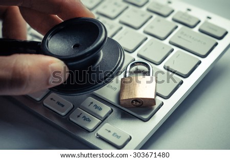 hand holding  a stethoscope over computer keyboard with a security lock - computer system check and maintenance concept
