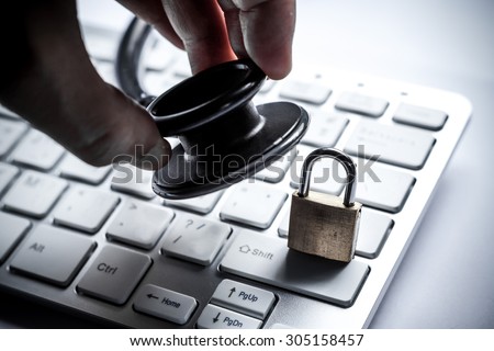 hand holding a stethoscope over computer keyboard with a security lock -computer system check and maintenance concept