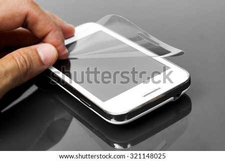 hand laying scratch protective film on a smartphone