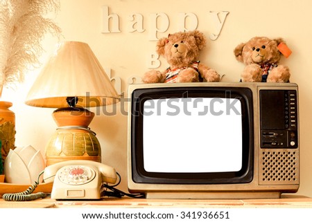 happy corner of a house with decoration of words saying think happy be happy, bear dolls, old telephone, vase, pot, lamp, plant, bird feather, basket, television