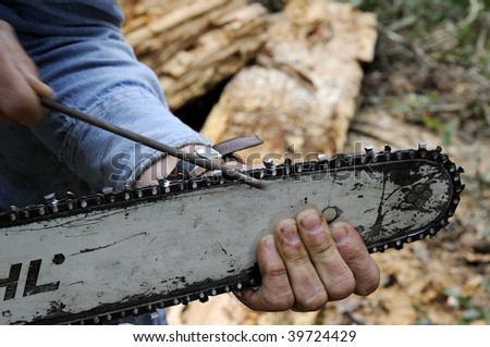 Man Sharpening Chain Saw Blade