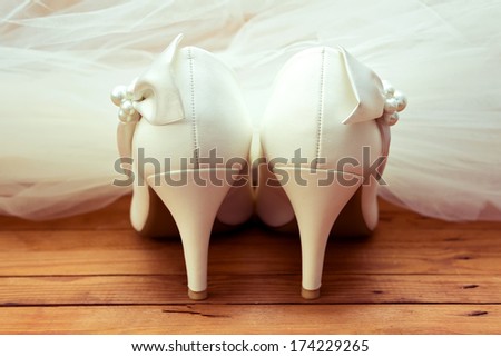 Wedding shoes and veil. White wedding shoes and veil on the old wooden floor