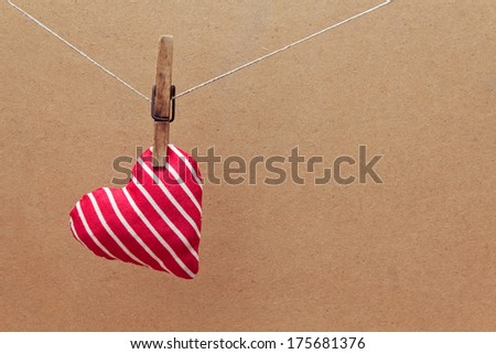 Red heart made ??of cloth hanging on the clothesline. Love design