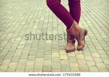Young girl stands in the shoes cross legged. Closeup shoes