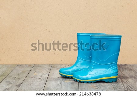 Blue rubber boots on a wooden floor. Autumn season concept