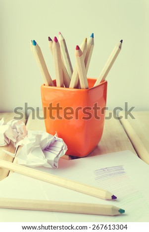 Cup with colorful Pencils on wooden table. Toned image