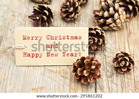 Pine cones and tag. Space for text. Pine cones on wooden background