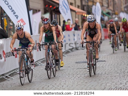 STOCKHOLM - AUG, 23:  World Triathlon  event Aug 23, 2014. woman bikes in Old town, Stockholm, Sweden