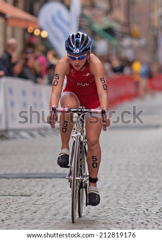 STOCKHOLM - AUG, 23:  World Triathlon  event Aug 23, 2014. woman bikes in Old town, Stockholm, Sweden. Magdalena Mielnik, POL.