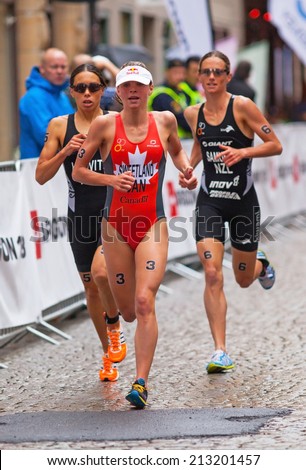 STOCKHOLM - AUG, 23:  World Triathlon  event Aug 23, 2014. woman running in Old town, Stockholm, Sweden.  Andrea Hewitt NZL. Nicky Samuels, NZL. Kirsten Sweetland , CAN.