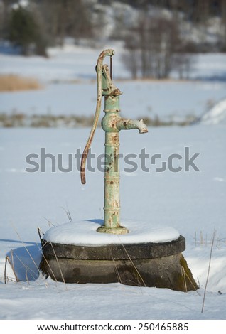 A light green water pump on a sunny winter day