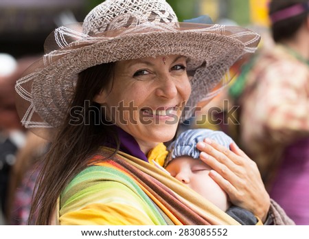 STOCKHOLM, SWEDEN - MAY 31, 2015. Peace and Love Parade. Street party in Stockholm, Young woman carrying little baby.