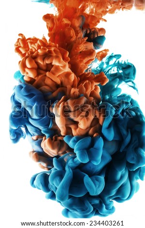 Color drop in water, photographed in motion. Ink swirling in water. Cloud of silky ink in water isolated on white background. Colorful ink in water, ink drop. Orange and blue, cyan color.