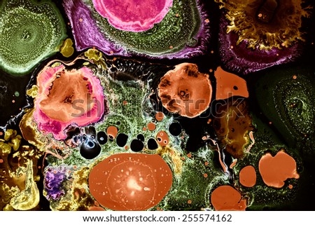 Surface structure of Liquid colors. Organic shapes floating. Orange green and pink smear on black.