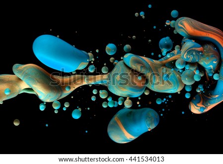 Color Liquid in dynamic flow forming interesting and unique shapes and bubbles. Colorful blue and orange tones mixing in an unique pattern. Artistic design. Isolated on black background.