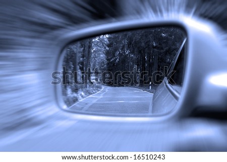 Zoom effect on exterior rear view mirror with rural woodlands
