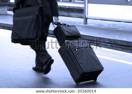 Businessman pulling a trolley at station