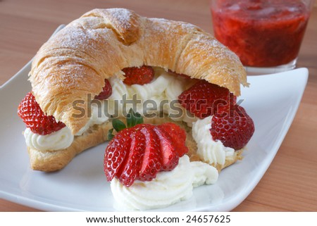 Fresh croissant stuffed with cream and fresh strawberry