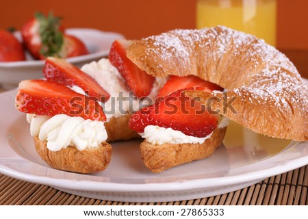 French croissant stuffed with cream and fresh strawberries