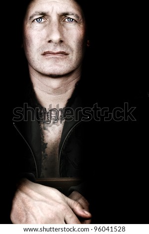 Serious looking man with blue eyes over black
