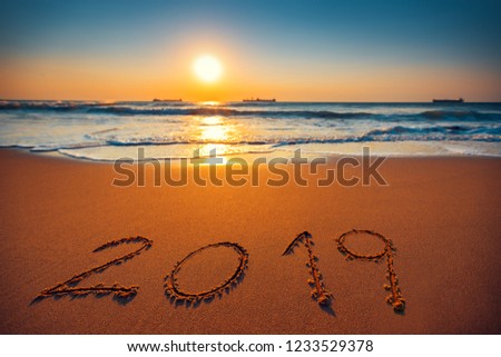 Happy New Year 2019 concept, lettering on the beach. Sea sunrise.