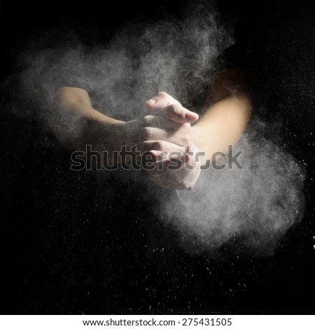 Chef hand clap and white flour on black background