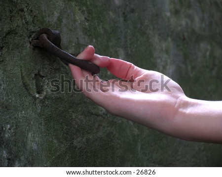 hand on an old horse hitching ring on a historical wall