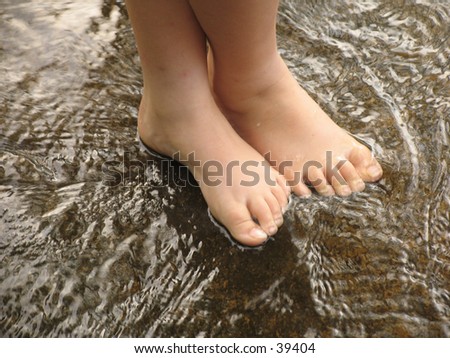 Child\'s feet wading in shallow water