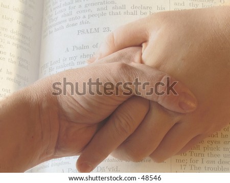 2 hands clasped together imposed on pages from Bible, 23 psalm.