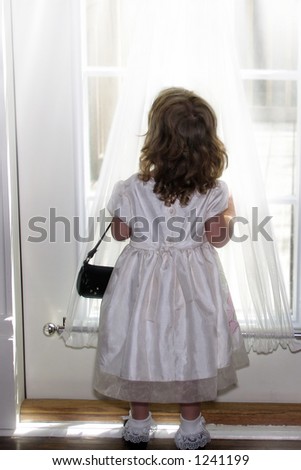 Little girl dressed up standing in diffused window light