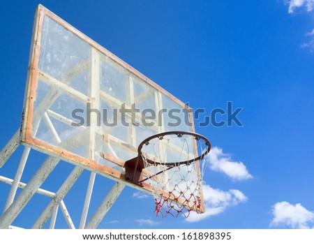 Light basketball hoop and net against blue sky