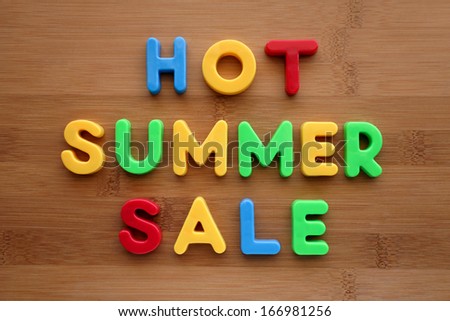 The words Hot Summer Sale spelled out in colourful letters on a wooden surface.