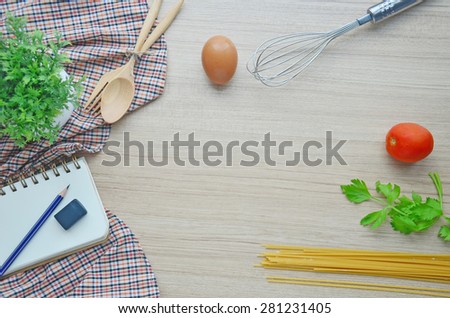 Cooking tools and blank note on the wood table - Top view
