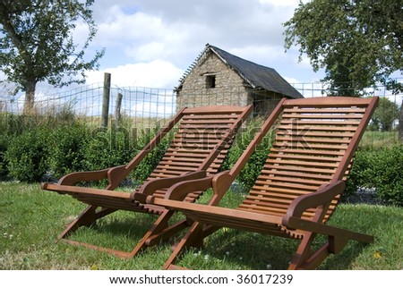 Relaxing chairs in a field next to a cottage