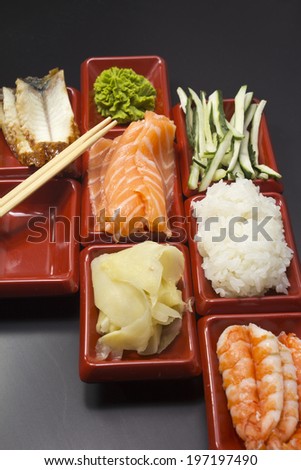 Ingredients for sushi: sliced salmon cucumber rice wasabi and ginger
