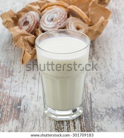 Seet fresh cookies with a cup of milk over wooden vintage background